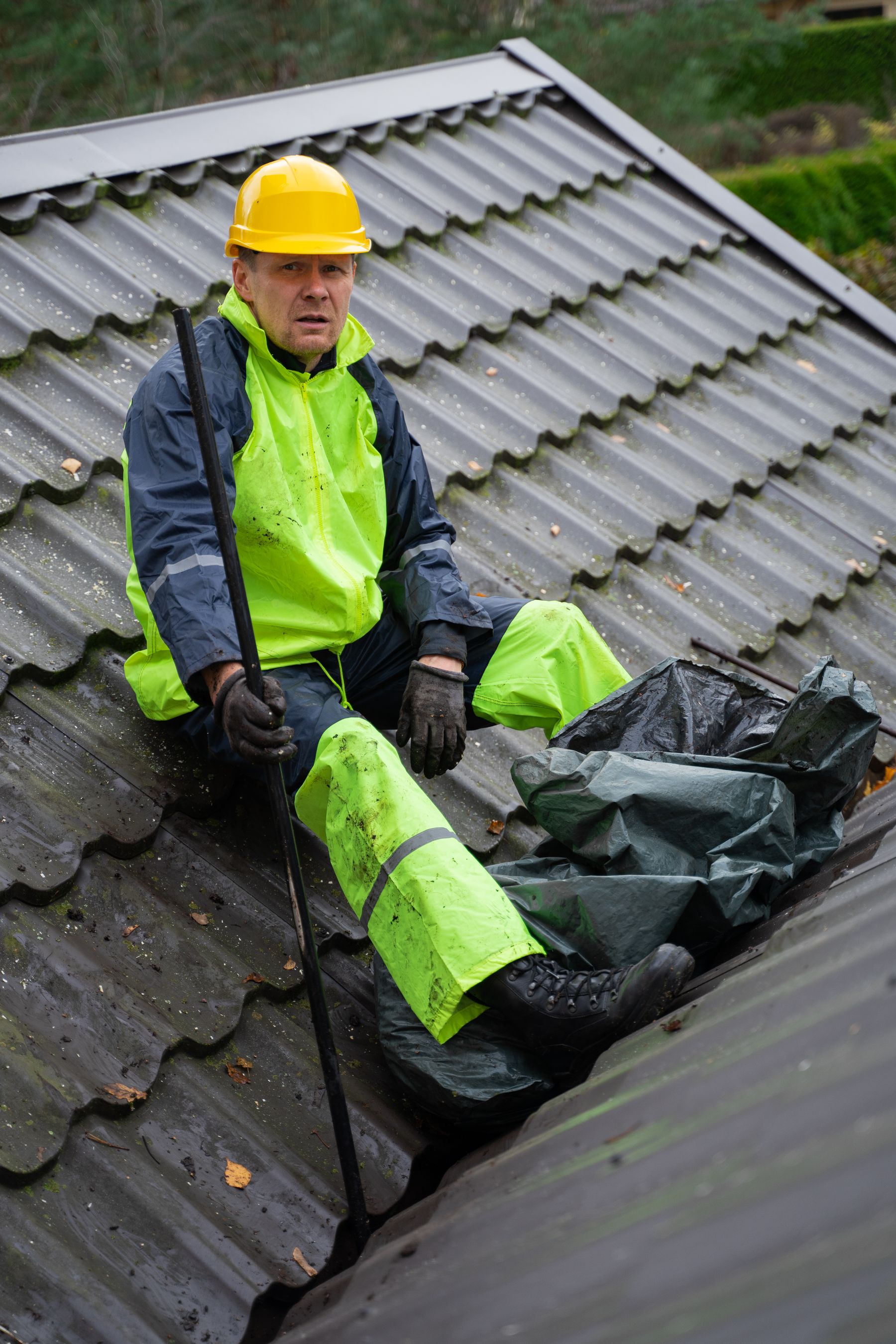 Illustrative roofing photograph: a roofer working on a tiled roof