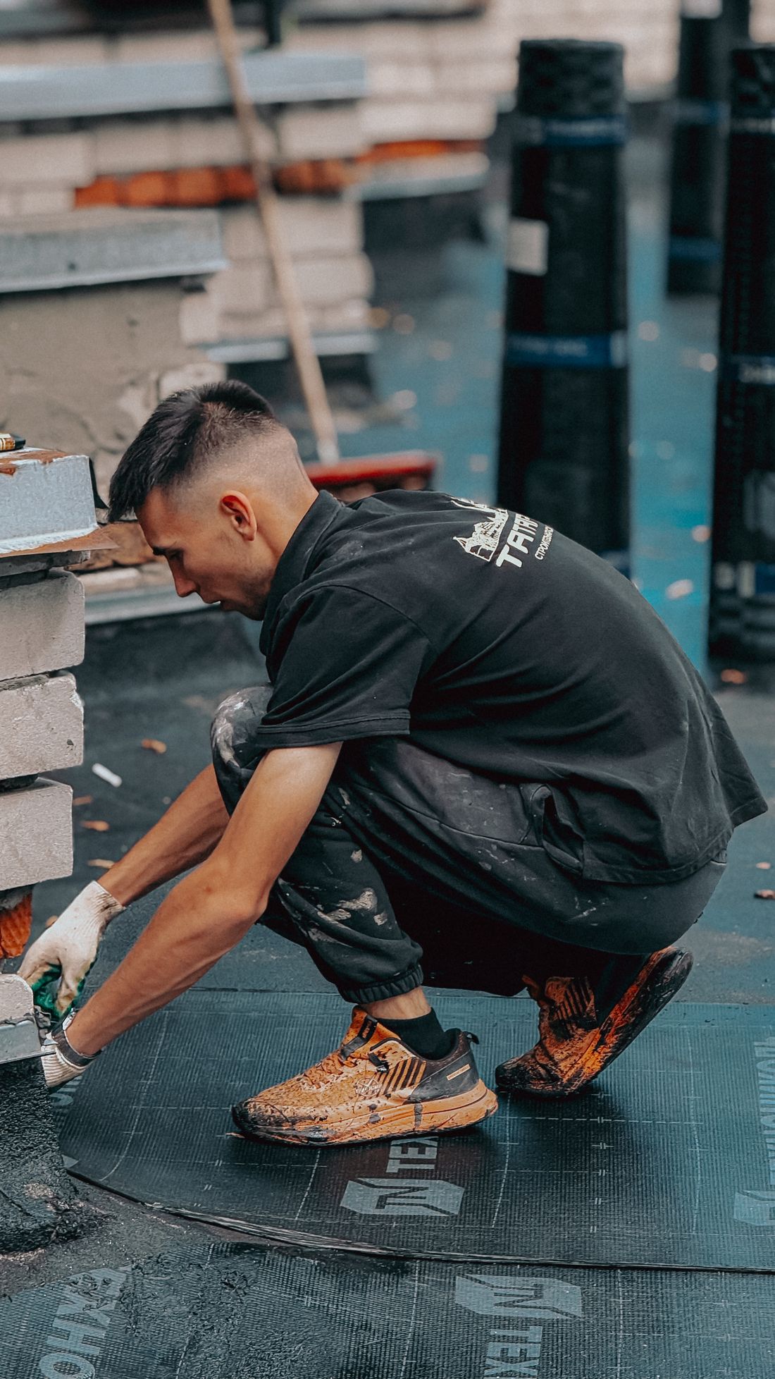Illustrative photograph of a roofer working on membrane beside brickwork